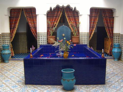 a blue altar in a room with vases and candles at Riad Tiziri in Marrakesh