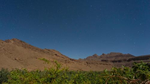 a starry night in the desert with mountains at Kasbah Hotel Camping Jurassique in Ifri