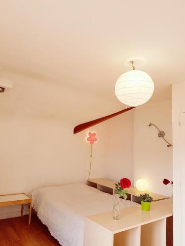 a bedroom with a bed and a table with flowers on it at NDP Family (Ndong Du Pierrier) in Montigny-lès-Cormeilles