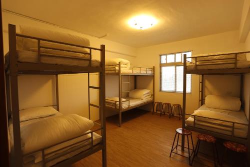 台東市的住宿－宏隆米絞青旅民宿 ，客房设有四张双层床和窗户。