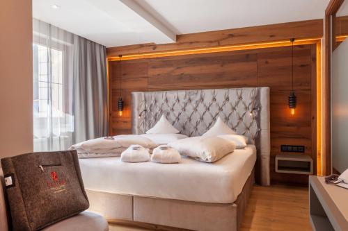 ein Schlafzimmer mit einem großen Bett mit weißen Kissen in der Unterkunft Hotel Platzer Superior in Gerlos