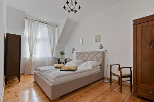 a bedroom with a bed and a chair at Imperial Apartments - Moderna in Sopot