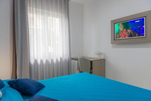 a bedroom with a bed and a tv on the wall at Hotel America in Scafati