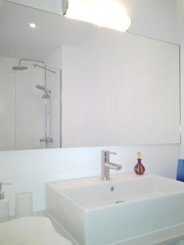 a white bathroom with a sink and a mirror at Vivienda Atlantico in Tazacorte