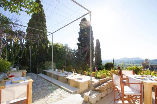 een patio met een tafel en stoelen in een tuin bij Can Cota Boutique - Turismo de interior in Selva