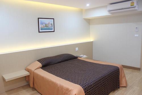 a small bedroom with a bed in a room at Charoen Hotel in Udon Thani