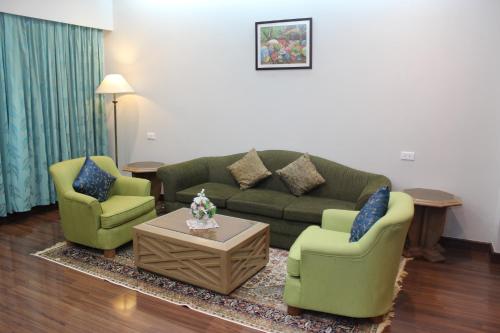a living room with a couch and two chairs at Charoen Hotel in Udon Thani
