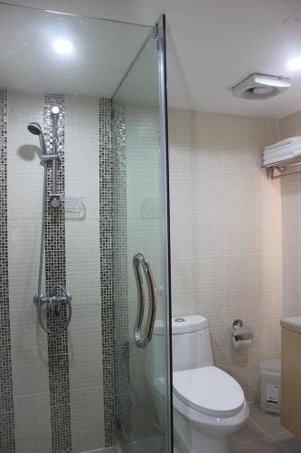 a bathroom with a toilet and a glass shower at Charoen Hotel in Udon Thani
