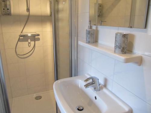 uma casa de banho com um lavatório e um chuveiro em Bed & Breakfast "Bij de Trekgaten" em Hollandscheveld