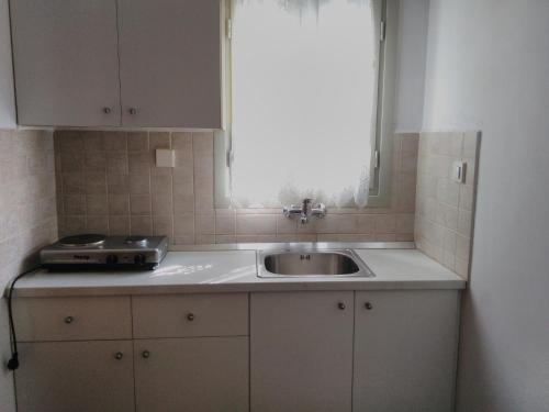 a kitchen with a sink and a window at Ioli Apartments in Naousa