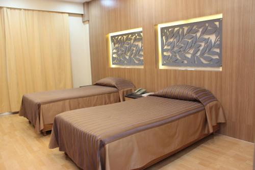 a hotel room with two beds in a room at Charoen Hotel in Udon Thani