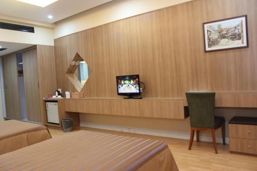 a hotel room with a tv on a wall at Charoen Hotel in Udon Thani