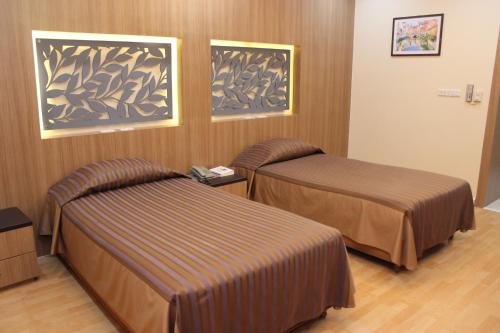a room with two beds in a hotel room at Charoen Hotel in Udon Thani