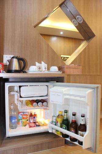 a refrigerator with its door open in a kitchen at Charoen Hotel in Udon Thani