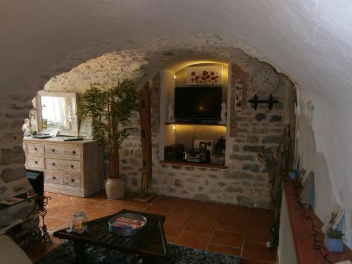 a living room with a table and a tv at Gite l'Etape in Vallon-Pont-dʼArc