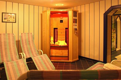 a room with two chairs and a drink cooler at Hotel Burgstein - alpin & lifestyle in Längenfeld