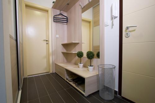 a bathroom with two potted plants on a shelf at Lux Life Apartment in Belgrade