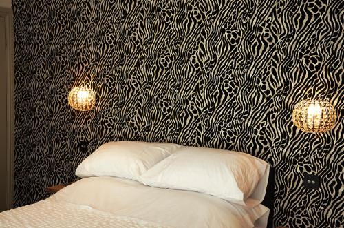 a bedroom with a black and white patterned wall at Frankies Wine Bar & Lodge in Disley