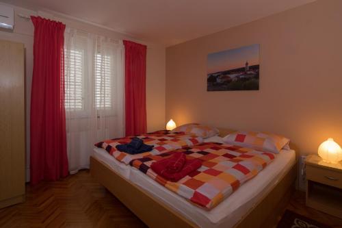 a bedroom with a bed with a checkered blanket at Apartments Villa Mare in Krk