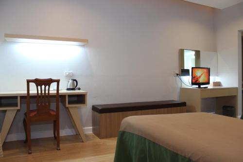 a bedroom with a desk and a bed and a chair at Charoen Hotel in Udon Thani