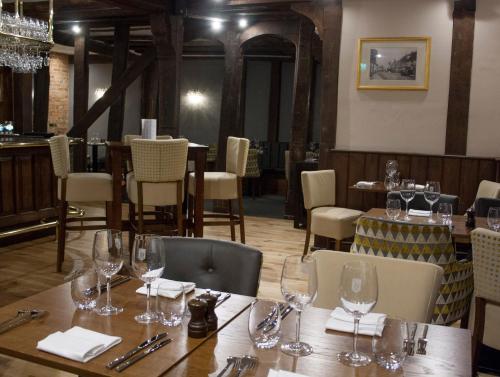 莫尔登The Swan Hotel Bar and Grill的用餐室配有带酒杯的桌子