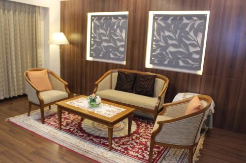a living room with two chairs and a coffee table at Charoen Hotel in Udon Thani