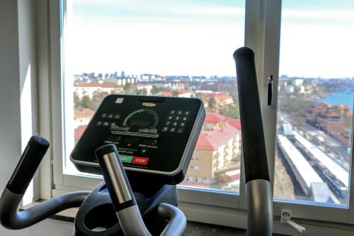 a gym with a view of a city from a window at Forenom Hotels & Apartments Stockholm Alvik in Stockholm
