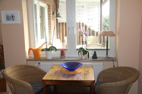 einen Tisch mit zwei Stühlen und eine blaue Schüssel darauf in der Unterkunft Sonnengruss am Strand in Eckernförde