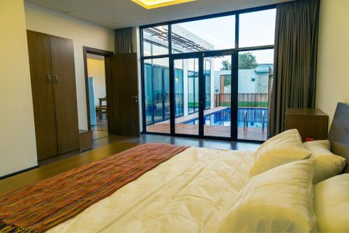 1 dormitorio con cama grande y ventana grande en Villa Blanche en Unayzah