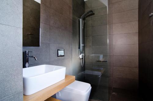 a bathroom with a sink and a shower and a toilet at Seametry Apartments in Souda
