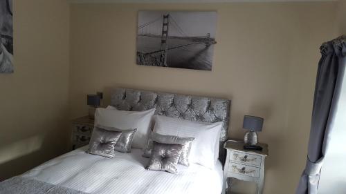 a bedroom with a bed with white sheets and pillows at Star Inn Rooms in Ardersier