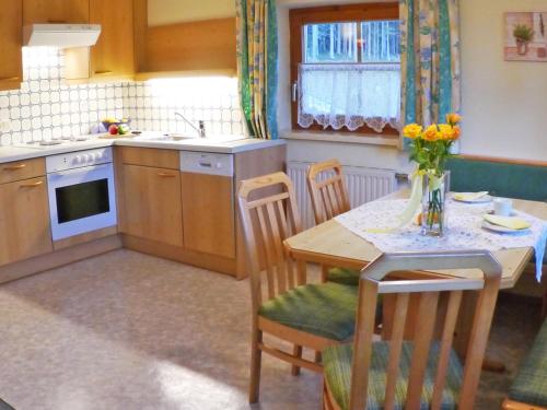 Una cocina con una mesa de madera y una mesa y sillas. en Landhaus Wiederkehr, en Ramsau am Dachstein