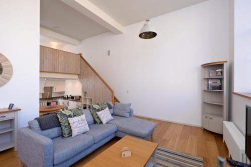 a living room with a blue couch and a table at Destiny Scotland - Broughton St Lofts in Edinburgh