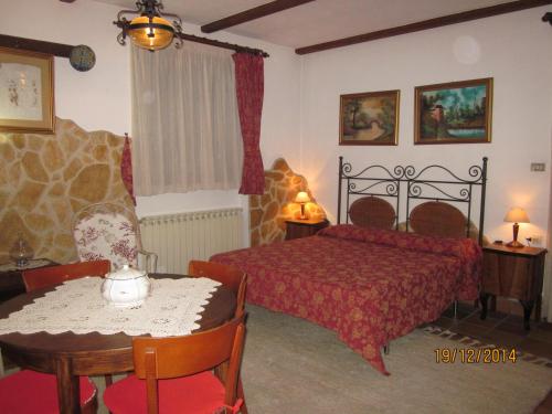 a bedroom with a red bed and a table and chairs at Bed&Breakfast Le Valli del Cerrano in Pineto