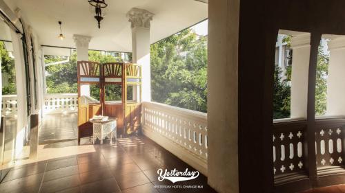 - une terrasse couverte avec une chaise et 2 fenêtres dans l'établissement Yesterday Hotel, à Chiang Mai