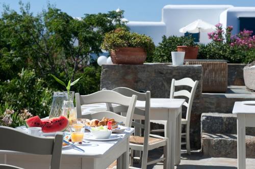 a table and chairs with food on a patio at Elena Hotel Mykonos in Mýkonos City