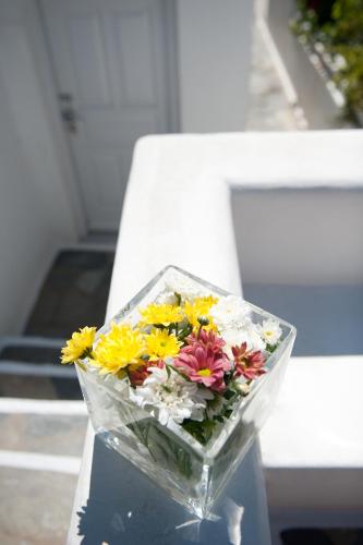 a bouquet of flowers in a glass bowl on a table at Elena Hotel Mykonos in Mýkonos City