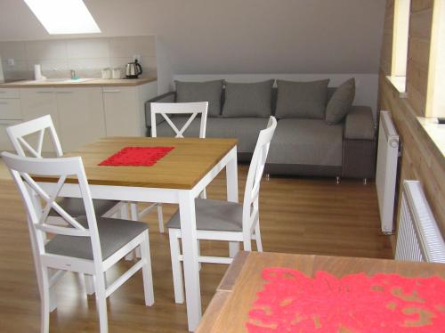 a kitchen and living room with a table and chairs at Dom Piotra in Goniadz
