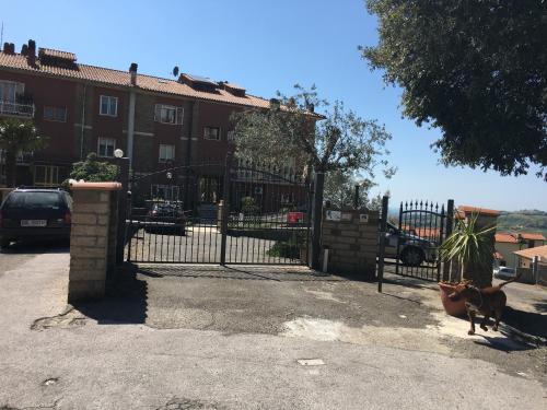 a dog standing next to a gate in front of a building at Casa Vacanze Elisa in Manciano