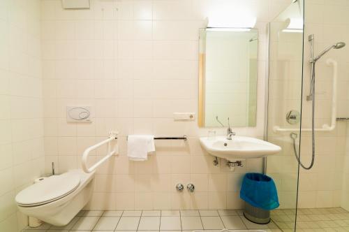 a bathroom with a sink and a toilet and a shower at Kolpinghaus Bolzano in Bolzano