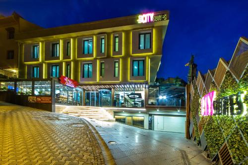 een geel gebouw met een bord erop bij The City Suites in Istanbul