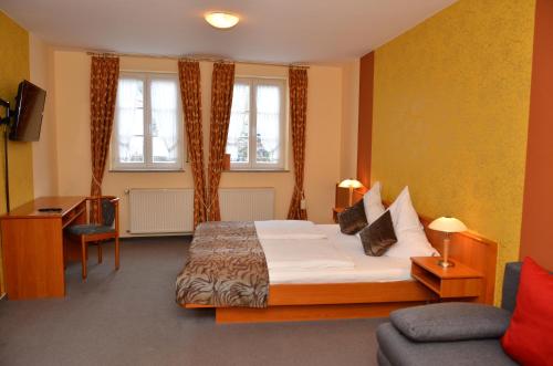 1 dormitorio con cama, escritorio y sofá en Gasthaus Zur Rebe, en Mehring