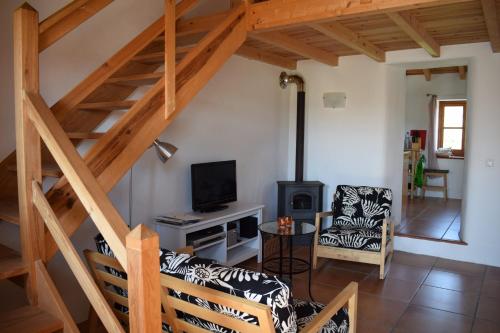 a living room with a staircase and a couch and a television at Vale da Palha in Casal do Pardo