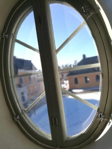 a round window with a view of a city at Wärdshuset Gammel Tammen Österbybruk in Österbybruk