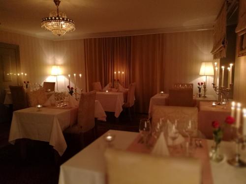 a dining room with two tables and a chandelier at Wärdshuset Gammel Tammen Österbybruk in Österbybruk