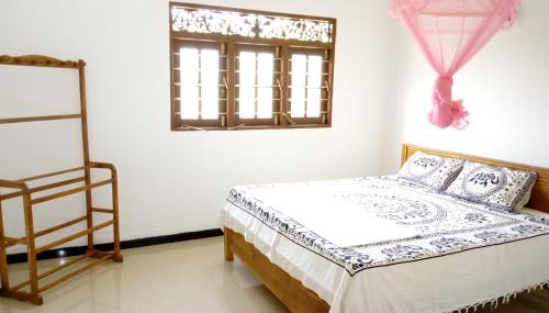 a bedroom with a bed and a window at Dreams Villa in Hikkaduwa