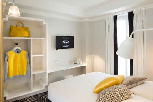 a hotel room with a bed and a tv at Hôtel Pastel Paris in Paris