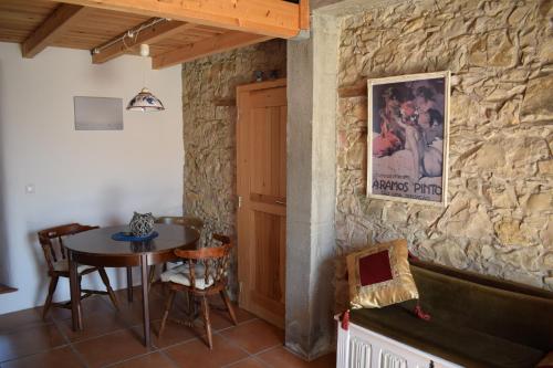 a dining room with a table and a stone wall at Vale da Palha in Casal do Pardo