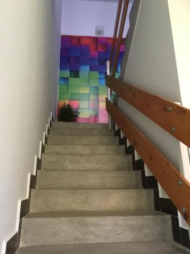 a staircase with a rainbow mural on the wall at SenoRita in Miskolc