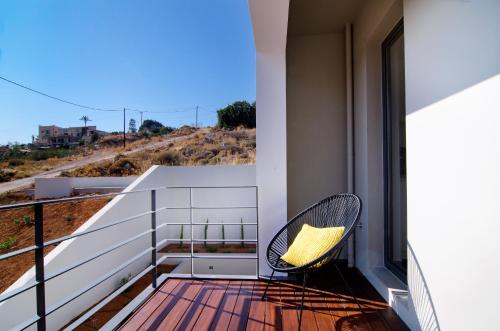a balcony with a chair and a view of a hill at Seametry Apartments in Souda